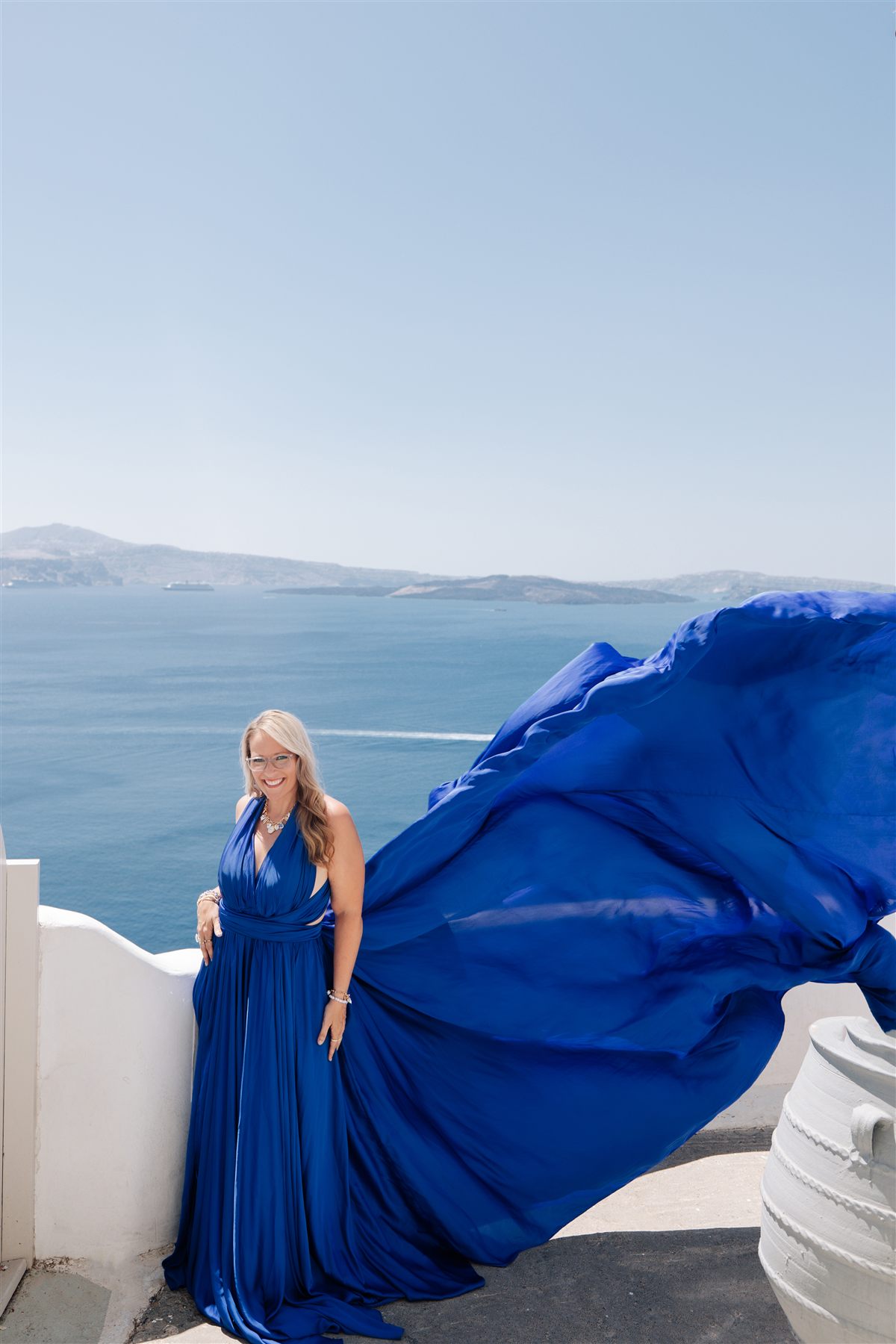 Jen in a flying blue dress above the caldera, Santorini